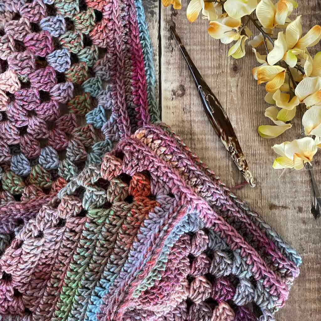 this infinity scarf is made with granny squares that are half solid and half granny stitch