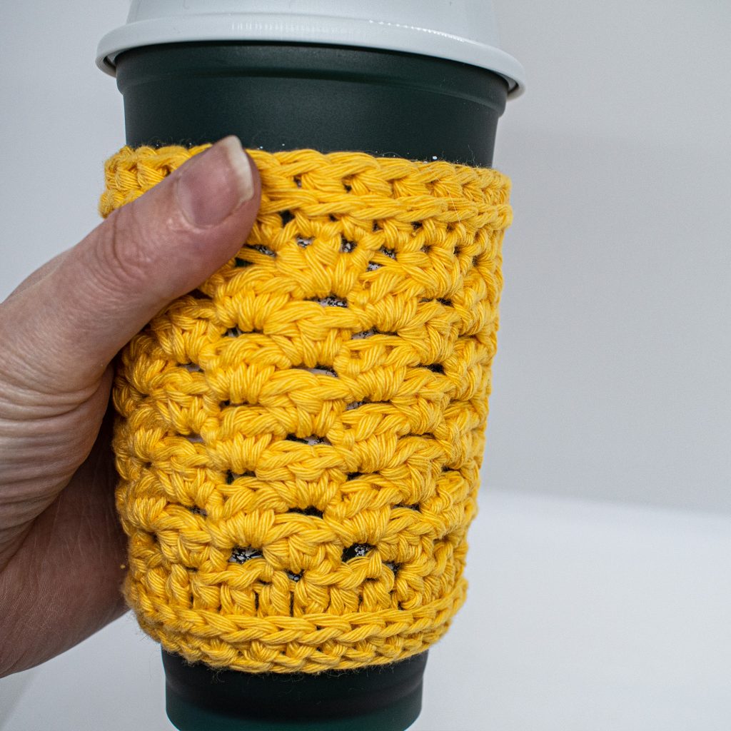 The modified granny stitch in this cup cozy design helps to protect your hands from the heat (or cold) of you cup when you are on the go.